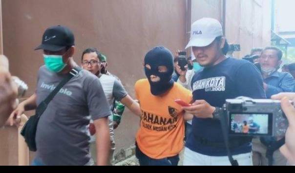 Petugas menggiring Rahmadsyah (30), tersangka kasus pembunuhan 2 anak di Polrestabes Medan, Senin (22/6/2020). Pembunuhan yang dilakoni ayah tiri di kawasan sekolah Global Prima, Jalan Brigjen Katamso, Gang Abadi, Medan.