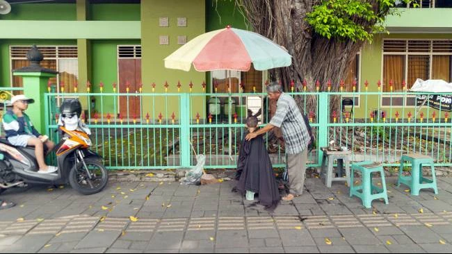 Lokasi Udin membuka usaha jasa cukur rambut di kawasan Alun-Alun Utara, Kota Yogyakarta, MInggu (30/3/2025).
