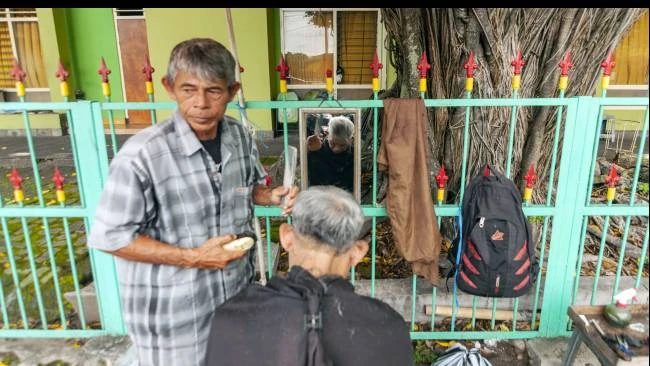 Udin, tukang cukur di kawasan Alun-Alun Utara, Kota Yogyakarta, mengaku menjelang Idulfitri semacam ini pelanggannya bisa meningkat hingga dua kali lipat, Minggu (30/3/2025).