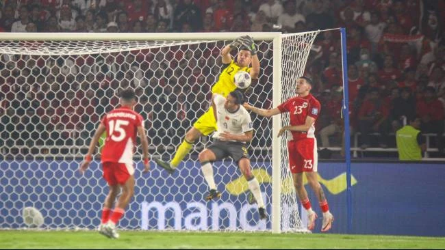 Emil Audero berusaha menangkap bola dan berduel dengan Zhang Yuning saat laga Indonesia vs China di Stadion Gelora Bung Karno, Jakarta, Kamis (5/6)