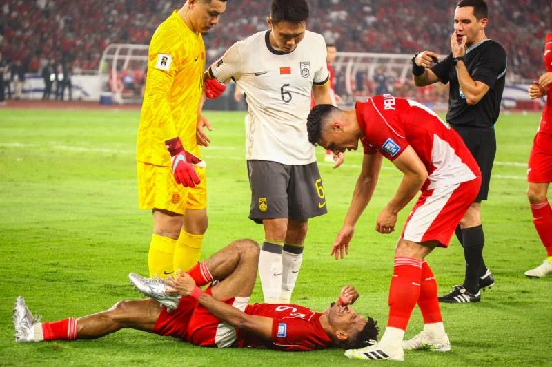 Ricky Kambuaya merintih kesakitan akibat berbenturan dengan Wang Shangyuan saat laga Indonesia vs China di Stadion Gelora Bung Karno, Jakarta, Kamis (5/6)