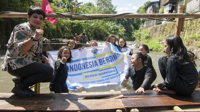 Seorang perwakilan Badan Narkotika Nasional Provinsi (BNNP) Daerah Istimewa Yogyakarta berpose dengan sejumlah anak Kampung Badran, Bumijo, Kecamatan Jetis, Kota Yogyakarta, saat menghadiri kegiatan Merti Mbelik di kampung tersebut, Kamis (10/7/2025). 