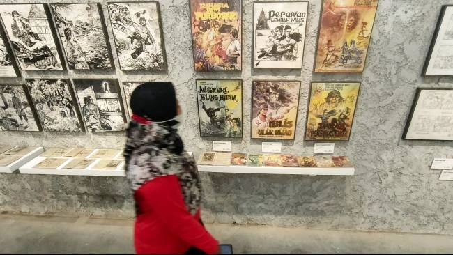 Seorang pengunjung melintas di depan gambar ilustrasi karya Win Dwi Laksono yang dipamerkan di Equalitera Art Space, Bantul, Yogyakarta, Minggu (13/7/2025). 
