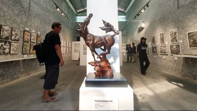 Sejumlah pengunjung memperhatikan sketsa dan ilustrasi karya Win Dwi Laksono, yang dipamerkan di Equalitera Art Space, Bantul, Daerah Istimewa Yogyakarta, Minggu (13/7/2025).