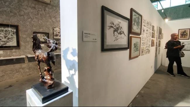 Patung kuda yang terletak berdekatan dengan gambar ilustrasi kuda karya Win Dwi Laksono, yang dipamerkan di Equalitera Art Space, Bantul, Daerah Istimewa Yogyakarta, Minggu (13/7/2025).